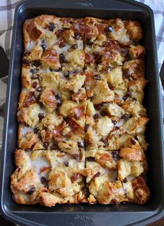 a pan filled with bread and raisins on top of a table