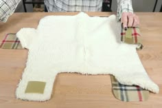 a person is making a sheepskin rug on a table