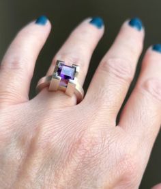 A Four Peaks Arizonan Amethyst set in a well protected, cast 4 v-shape claw ring.  A minimalist, geometric design with the setting being a distinctive design feature.  The ring has a brushed finish with a high polished top and contrasting burnished edges. IN STOCK This ring is a size 5.5 and could be sized up to 5.75. Amethyst is one of my favourite stones and I often incorporate this gem into my work.  This Four Peaks Amethyst is a unique gem as it has slight colour zoning in it which plays ver Modern Amethyst Ring As Gift, Modern Purple Amethyst Ring For Anniversary, Modern Amethyst Wedding Ring, Modern Amethyst Ring With Center Stone For Formal Occasions, Modern Amethyst Ring For Wedding, Modern Amethyst Ring Perfect As A Gift, Modern Purple Wedding Rings, Modern Sterling Silver Amethyst Ring For Formal Occasions, Modern White Gold Amethyst Ring