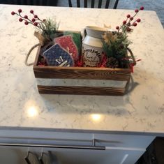 a wooden box filled with assorted items sitting on top of a kitchen counter next to a stove