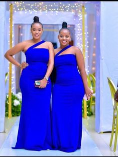 two women in blue dresses standing next to each other