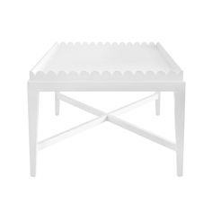 a white table with scalloped edges on the top and bottom, against a white background