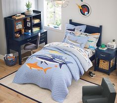 a child's bedroom with a bed, desk and chair in the corner that has an ocean theme on it