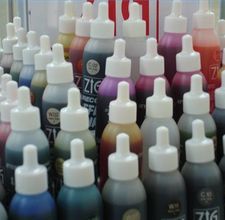 many different colored ink bottles are lined up