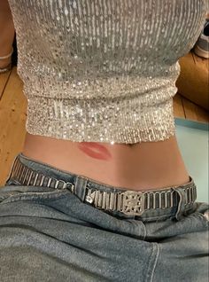 a woman's stomach showing the bottom part of her body with silver sequins on it