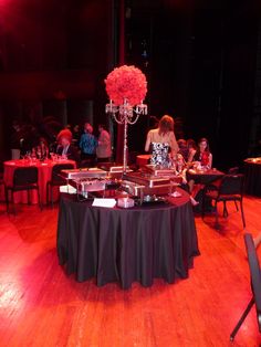 a table that has some food on it and people sitting at tables in the background