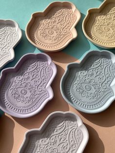 six different shaped trays sitting on top of a blue and pink tableclothed surface