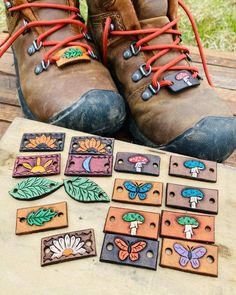 a pair of brown boots sitting on top of a wooden table next to small magnets