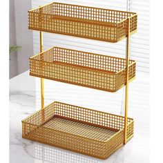 three tiered gold metal shelf with baskets on each side and white marble counter top