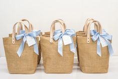 three straw bags with blue bows on them