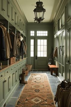 a long hallway with lots of closets and coats hanging on the wall next to it