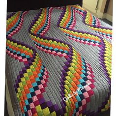 a bed with a colorful quilt on top of it