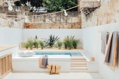 an outdoor bathroom with a jacuzzi tub and towels hanging on the line above it