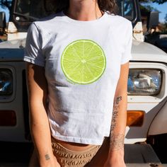 Introducing our Lime Baby Tee, a refreshing nod to Y2K fashion and vintage charm! Embrace the vibrant energy of the early 2000s with this playful graphic tee featuring a zesty lime illustration that's sure to make a statement.  Sip on style with our graphic Lime Shirt, featuring a bold lime graphic that adds a dash of fun to any outfit, with the word "Lucky" printed underneath the image. Whether you're savoring the flavor of your favorite cocktail or simply soaking up the sun, this tee is the pe Y2k Summer Tops With Screen Print, Y2k Style Screen Print Summer Tops, Y2k Style Screen Print Tops For Summer, Y2k Style Summer Tops With Screen Print, Y2k Summer Screen Print Tops, Y2k Green Tops With Screen Print, Y2k Style Green Tops With Screen Print, Y2k Pre-shrunk T-shirt For Spring, Y2k Summer Cotton Shirt