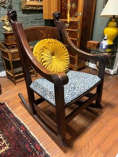 a wooden rocking chair sitting on top of a hard wood floor next to a rug