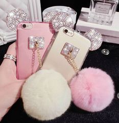 three cell phones with bows and pom - poms in front of some other accessories