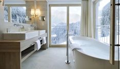 a large white bath tub sitting next to a window