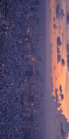 an aerial view of the city lights and beach at sunset from above, with clouds in the sky