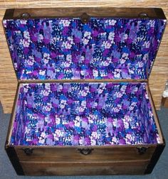 an old wooden trunk with purple flowers on it