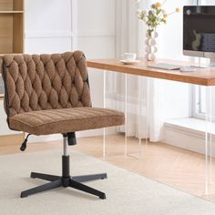 a brown office chair sitting in front of a desk with a computer monitor on it