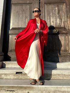 This red kimono robe is a stunning piece that combines elegance and comfort, making it a perfect addition to any wardrobe. Made from luxurious satin, this kimono robe offers a silky, smooth texture that feels exquisite against the skin. As a long kimono robe, it provides full coverage, ensuring both modesty and a touch of drama with its flowing silhouette. The long sleeves add to its sophisticated look, making it a standout piece for kimono homewear. This kimono dress can easily transition from Elegant Kimono As A Gift, Elegant Kimono With Kimono Sleeves As A Gift, Elegant Kimono With Kimono Sleeves For Gift, Summer Elegant Maxi Kimono, Elegant Summer Maxi Kimono, Summer Elegant Maxi Length Kimono, Elegant Floor-length Summer Kimono, Silk Maxi Length Kimono, Elegant Red Kimono For Spring