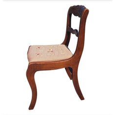 a wooden chair with a flowered seat cushion on it's backrests