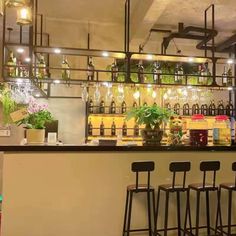 a bar with several stools and bottles on the wall behind it in a restaurant