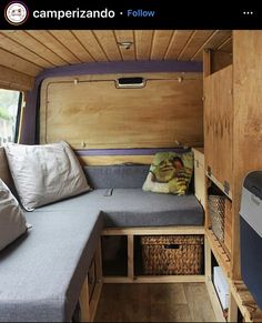 the inside of a campervan with its bed pulled out and storage drawers open