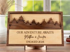 a wooden sign that says our adventure awaits, with trees on the front and back