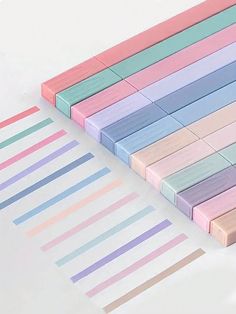 several strips of pastel colored paper laid out on top of each other with different colors