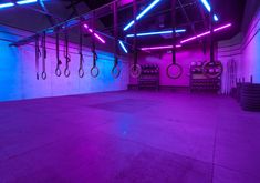 an empty gym with neon lights and purple lighting