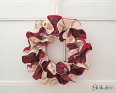 a red and white wreath hanging on the side of a door