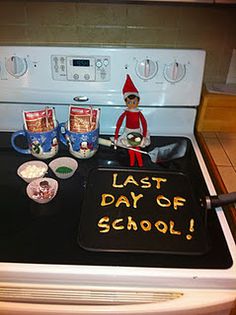 an elf is sitting on top of the stove with cups and spoons in front of him