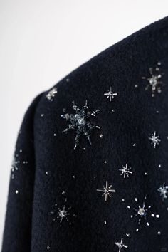 a black sweater with silver stars on it