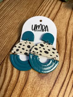 two pairs of polka dot earrings on top of a wooden table