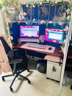 two computer monitors sitting on top of a desk next to each other in an office