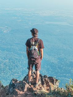 a man standing on top of a mountain looking down