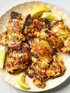 chicken with lemon wedges and parsley on a tortilla dish, ready to be eaten