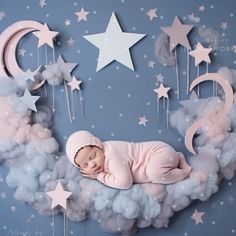 a baby sleeping on top of a cloud with stars and crescents in the sky