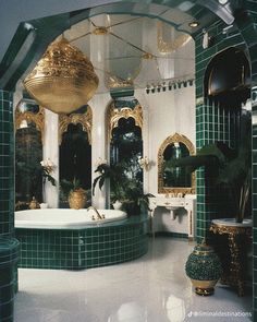 an ornate bathroom with green tiles and gold fixtures, including a large bathtub in the center