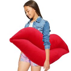 a woman holding a giant red pillow in front of her face