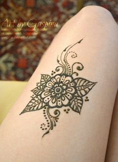 a woman's legs with henna tattoos on it and the bottom half of her leg