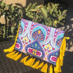 This Handbag Is Perfect For Those With A Strong Appreciation For Boho Chic. This Clutch Bag Is A Handcrafted Thai Handbag That Features An Embroidered Tribal Pattern Black Cotton Lining, Adorned With Tassels.This Clutch Is Sure To Ensure A Night Of Fun! Bohemian Tassel Clutch Bag, Bohemian Clutch Bag With Tassels, Travel Clutch Bag With Tassels, Vacation Tassel Clutch Bags, Bohemian Fringe Rectangular Clutch, Bohemian Rectangular Fringe Clutch, Bohemian Rectangular Clutch With Tassels, Bohemian Rectangular Clutch With Fringe, Traditional Multicolor Fringe Bag