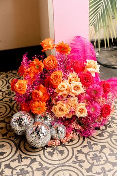 an arrangement of flowers and disco balls on the floor