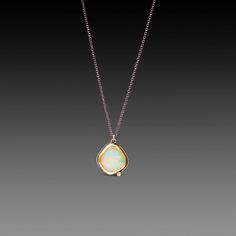 An organically-shaped, faceted Ethiopian opal, wrapped in a warm 22k gold bezel, and accented by a single, twinkling white diamond is suspended from an oxidized sterling silver chain in this magically stunning necklace. The opal is backed with sterling silver, and measures approximately 1/2 inch tall. Matte finish. Ethiopian Opal Necklace, Stunning Necklace, Opal Necklace, 22k Gold, Ethiopian Opal, Sterling Silver Chain, White Diamond, Sterling Silver Chains, Gold Chain