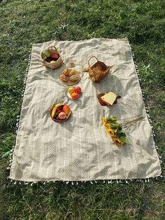 a picnic blanket with fruit and bread on it