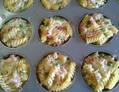 a muffin tin filled with lots of different types of pasta and meat in it