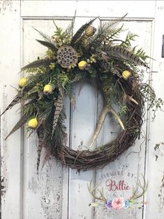 a wreath with flowers and antlers hanging on a door