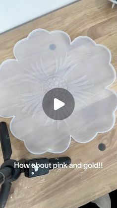 a video demonstrating how to cut out pink and gold paper flowers on a cutting board