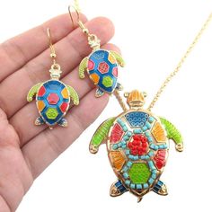 This jewelry set is perfect for those who love sea turtles! The turtle pendant is covered in enamel and colorful beads and hangs on a sturdy chain. The dangle earrings feature turtle charms that are bright and eye catching! Two pieces for the price of one! Store FAQ | Shipping Info | Returns & Exchanges Size: The turtle charms on the earrings measures 2.5 cm wide by 3.3 cm tall.The turtle pendant measures 5.6 cm tall by 4.9 cm wide and hangs on a 20 inch long chain that can be shortened with Multicolor Enamel Jewelry With Lobster Clasp, Nickel-free Multicolor Enamel Jewelry, Nickel-free Multicolor Jewelry For Beach, Nickel-free Multicolor Jewelry For The Beach, Multicolor Pendant Jewelry For Beach, Multicolor Jewelry With Matching Earrings For Beach, Turtle Charm, Turtle Pendant, Animal Jewelry